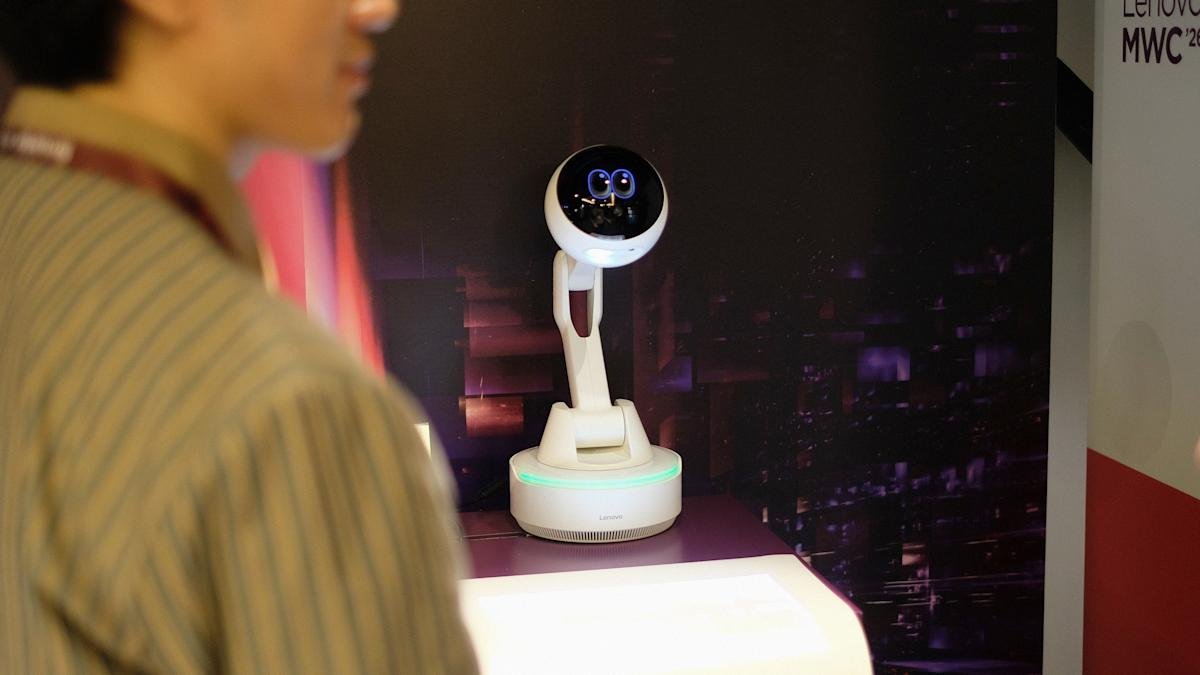 Lenovo AI Workmate Concept robot projecting an image onto a desk, with a hand signing a document.