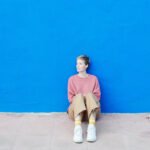 A solitary figure looking out, symbolizing loneliness, with a subtle overlay of a heart icon.