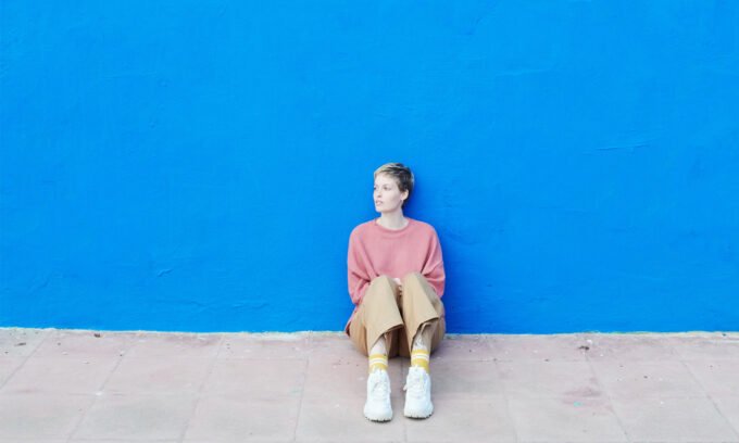 A solitary figure looking out, symbolizing loneliness, with a subtle overlay of a heart icon.