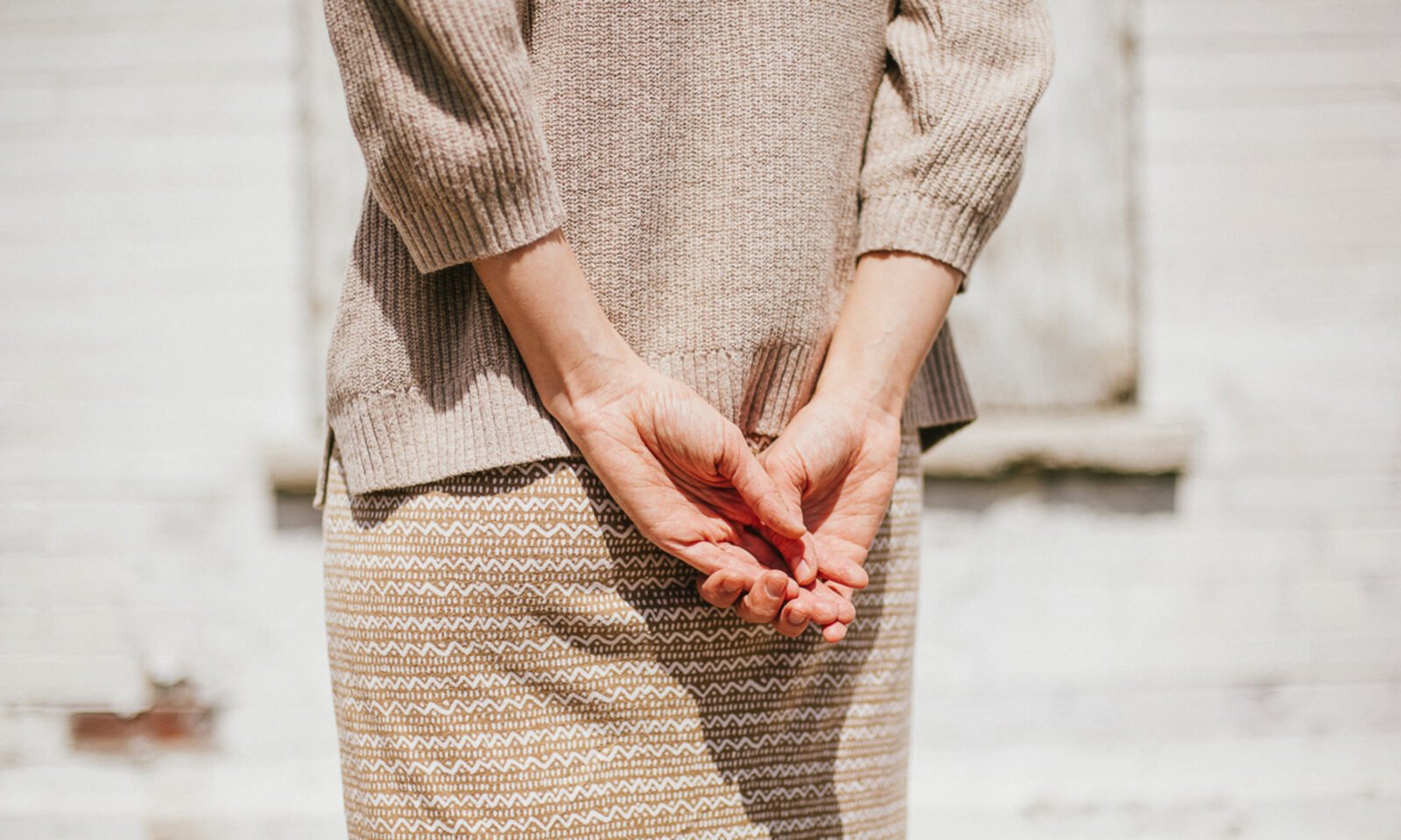 An individual performing a gentle exercise, possibly Tai Chi or yoga, to relieve low back pain.