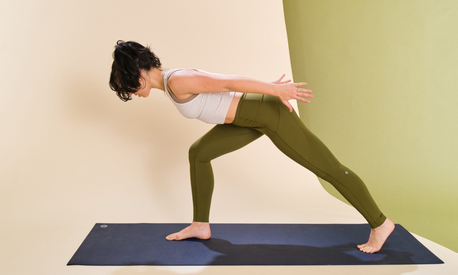 A person demonstrating a lunge with chest lift, hinging forward with a neutral spine to engage the core.