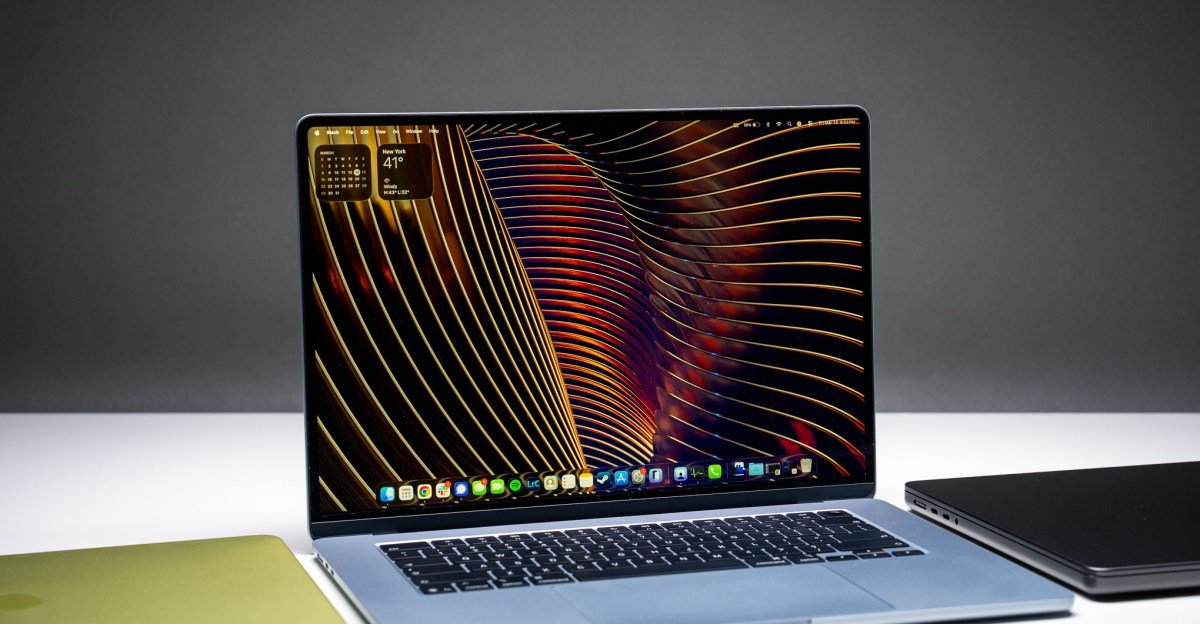 A MacBook Air M5 laptop positioned between a MacBook Neo and a MacBook Pro, illustrating Apple's laptop lineup.