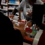 Une pharmacie marocaine avec des médicaments et un pharmacien, symbolisant le débat sur l'ouverture du capital des officines.