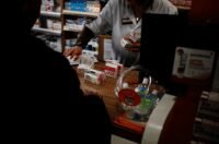 Une pharmacie marocaine avec des médicaments et un pharmacien, symbolisant le débat sur l'ouverture du capital des officines.