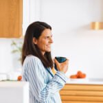 Woman experiencing menopause symptoms, looking thoughtful, with an overlay representing gut health or healthy food.