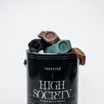 A collection of D1 Milano watches in various Tonester-inspired monochromatic colors, displayed against a minimalist Milanese backdrop.