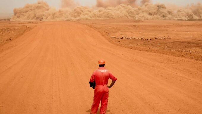 Vue aérienne panoramique de la mine de bauxite de Sangaredi en Guinée, montrant des excavations à ciel ouvert et des infrastructures minières sous un ciel dégagé. La mine est exploitée par la Compagnie des bauxites de Guinée (CBG).