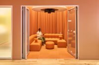 A person experiencing the multi-sensorial Emergence wellness session with an EEG headset in a calm, projected environment.