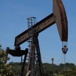 A pumpjack operates in the Inglewood Oil field, Los Angeles, California, symbolizing global oil production.