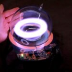 Unleash the Aurora: Building Your Own Plasma Toroid Generator 6 A glowing, stable toroidal ring of xenon plasma floating within a glass globe, powered by a DIY generator.