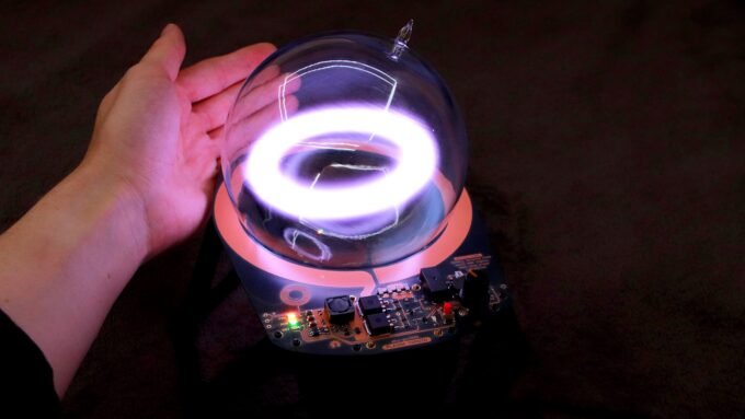 A glowing, stable toroidal ring of xenon plasma floating within a glass globe, powered by a DIY generator.