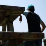 A young person looking intently at a screen, possibly a smartphone or computer, with abstract financial graphs or betting interfaces in the background, symbolizing online prediction markets and youth engagement.