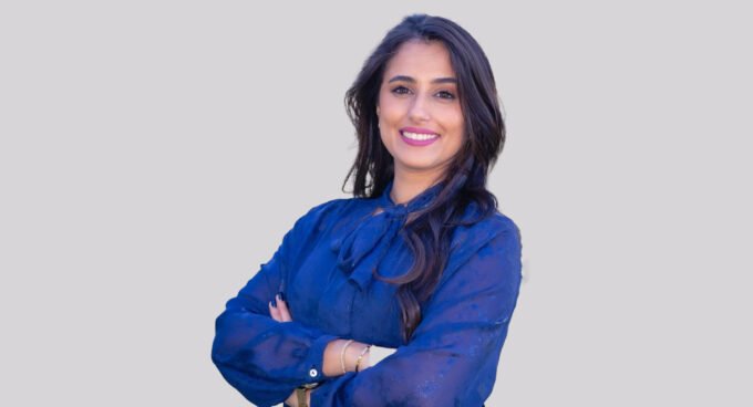 Une femme souriante tenant un yaourt, symbolisant les probiotiques et la santé intestinale, avec un arrière-plan flou évoquant le bien-être.