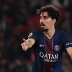 Paris Saint-Germain and Chelsea football players competing for the ball during a UEFA Champions League match.