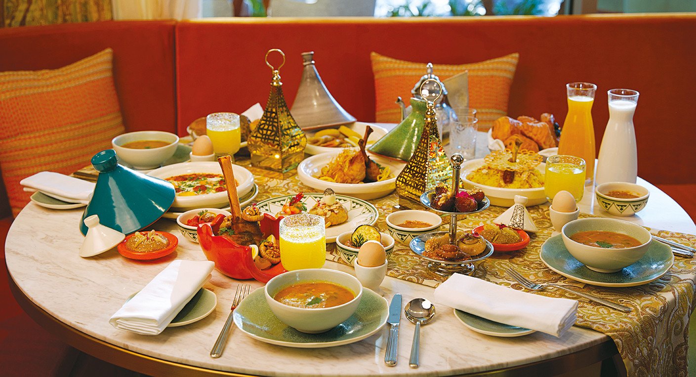 Une table de rupture du jeûne (Iftar) avec des plats variés, des dattes et des boissons, illustrant l'abondance du Ramadan.
