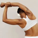 An older woman lifting weights, symbolizing strength and muscle preservation and healthy aging.