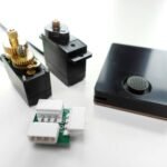 Beyond PWM: Mastering Smart Servos with the Oxocard Connect 4 An Oxocard Connect microcontroller connected to a Feetech SCS0009 smart servo, demonstrating serial communication for precise control.