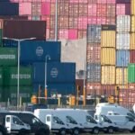 Gavel resting on legal documents with a backdrop of a US flag and trade-related charts, symbolizing a court ruling on tariffs.