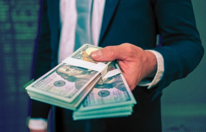 A panoramic view of the Wall Street financial district in New York City with skyscrapers and a bustling street scene, symbolizing record-breaking bonuses.