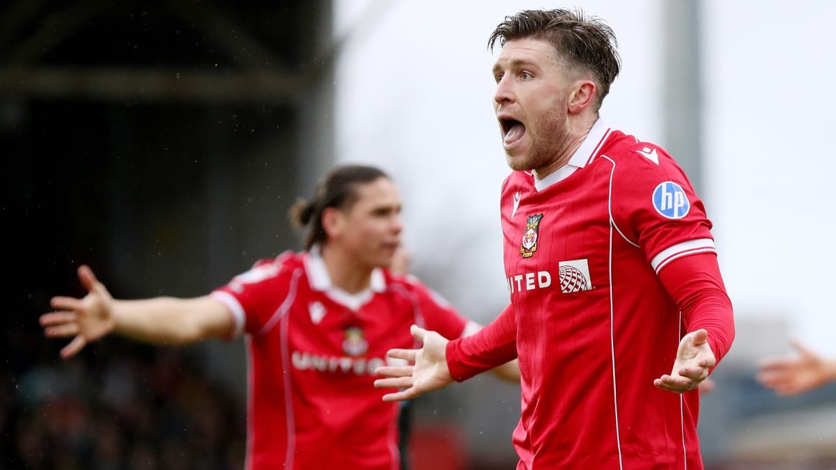Wrexham vs Chelsea FA Cup match action with fans in the background