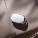 Le Xiaomi Tag, un petit traqueur d'objets noir avec un trou pour porte-clés, posé sur une surface claire.