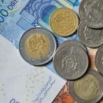 Illustration de la Zakat Al Fitr, montrant des mains donnant et recevant de l'argent ou de la nourriture, symbolisant la solidarité islamique et le partage.