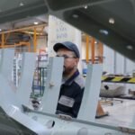 Usine aéronautique au Maroc, avec des avions en arrière-plan, symbolisant le développement industriel et l'innovation.