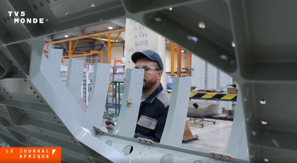 Usine aéronautique au Maroc, avec des avions en arrière-plan, symbolisant le développement industriel et l'innovation.