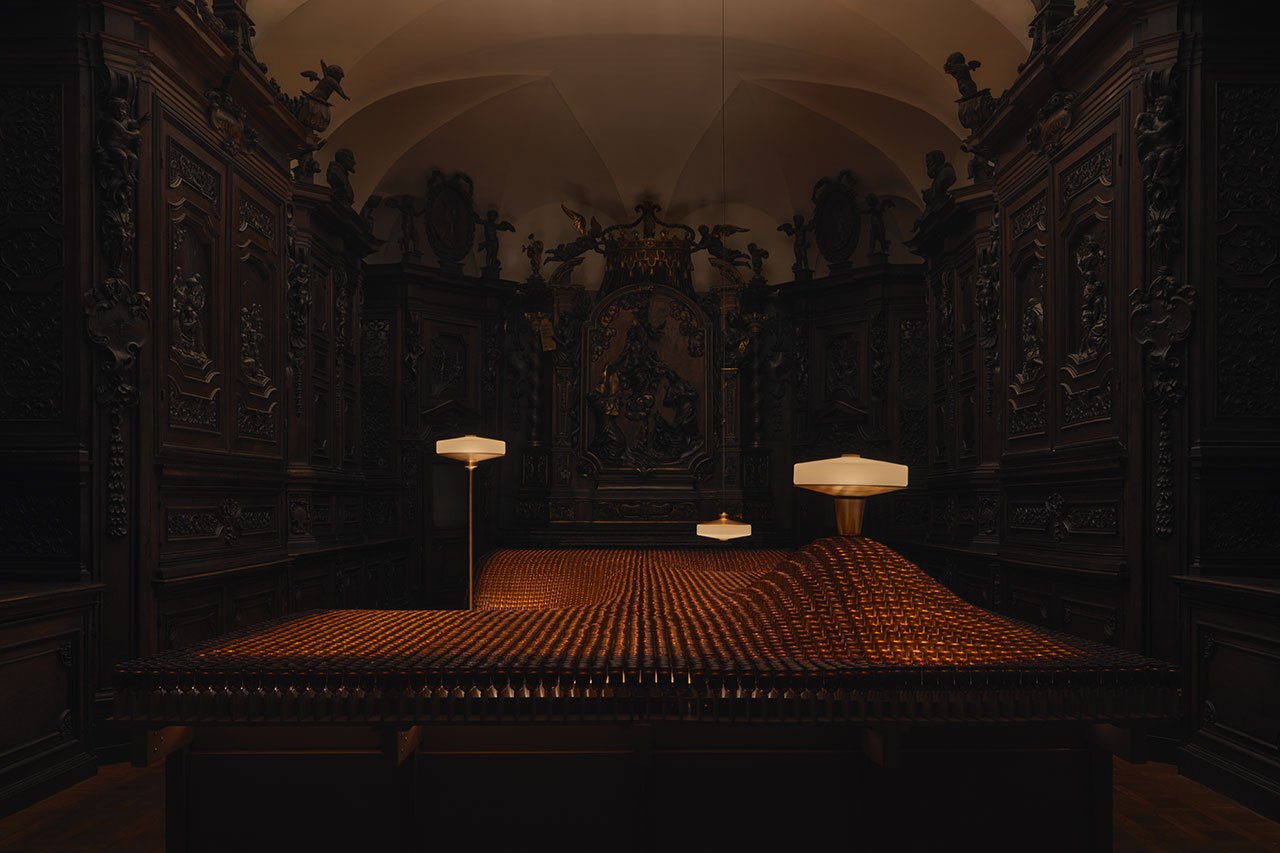 A mesmerizing view of Aesop's 'Factory of Light' installation in Milan, featuring Aposē lamps illuminating a landscape of recycled fragrance vials within a historic church.