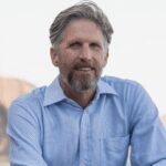 A determined entrepreneur, perhaps a person of middle age, looking confidently towards a bright future, symbolizing innovation and resilience in the tech industry.