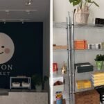 An AI robot looking confused or panicked in front of a modern, empty boutique storefront.