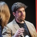 An abstract image showing interconnected molecular structures and glowing AI neural network elements, symbolizing AI-driven drug discovery entering human trials.