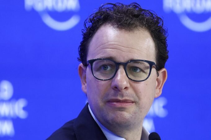 A stylized graphic representing AI technology, possibly with network lines and a subtle government or security agency emblem in the background.