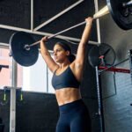 Unshod Power: Why Ditching Your Gym Shoes Could Be Your Ultimate Strength Upgrade 6 A person performing a deadlift barefoot in a gym, emphasizing foot connection to the ground.