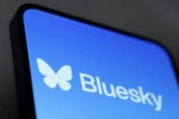 Bluesky logo against a backdrop of digital disruption or a server rack with warning signs