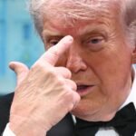 A person watching a conspiracy theory video on a smartphone, with social media logos in the background.