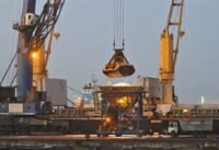 رافعة تفرغ شحنة أسمدة من سفينة شحن في ميناء موندرا بالهند، ترمز لأهمية حركة الأسمدة في التجارة العالمية.