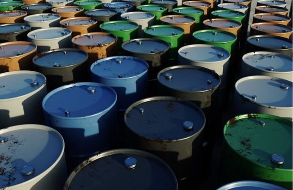 صورة توضيحية لبراميل نفط أو سفينة شحن في مضيق مائي يرمز لمضيق هرمز، تعكس التوترات الجيوسياسية.