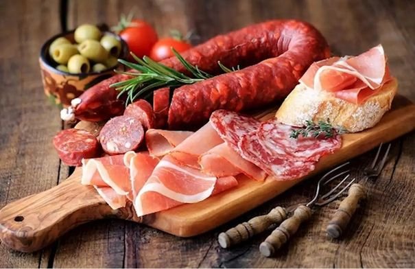 صورة لمجموعة من الأطعمة الشائعة مثل الحلويات واللحوم المصنعة والعصائر، مع إشارة تحذيرية.