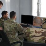 صورة توضيحية لجنود مغاربة وأمريكيين يتبادلون المعلومات عبر أنظمة اتصالات عسكرية متطورة.