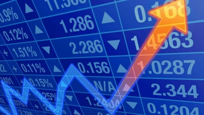 شاشة تعرض مؤشرات الأسهم الأمريكية مع رسوم بيانية صاعدة.