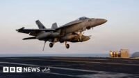 مقاتلة أمريكية من طراز F/A-18E تستعد للهبوط على حاملة الطائرات أبراهام لينكولن في عرض البحر.