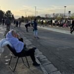 عضو في قوات الأمن الإيرانية يراقب حركة المرور أمام لوحة إعلانية كبيرة في ساحة انقلاب بطهران، تحمل عبارة "مضيق هرمز سيبقى مغلقاً" باللغة الفارسية، بتاريخ 5 أبريل 2026.