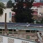 صورة تظهر أقسامًا مدرسية مغطاة بالبلاستيك في وزان، مع تلاميذ يدرسون في ظروف صعبة.