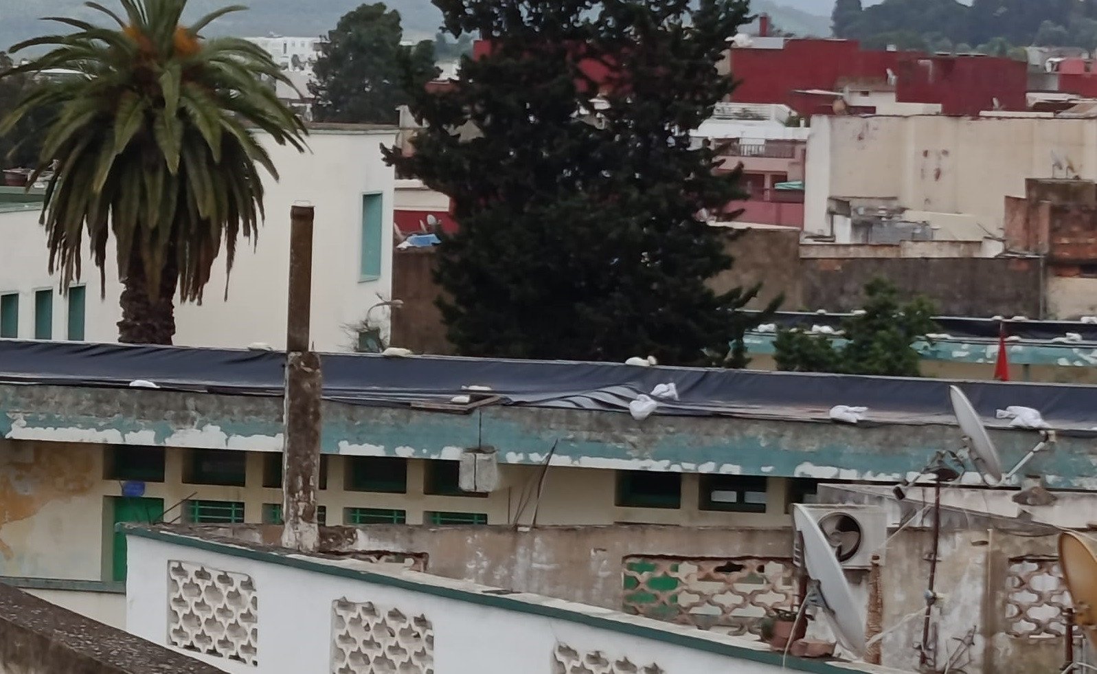 صورة تظهر أقسامًا مدرسية مغطاة بالبلاستيك في وزان، مع تلاميذ يدرسون في ظروف صعبة.