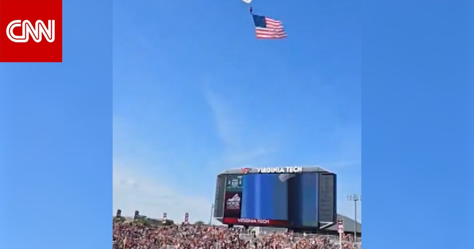 مظلي معلق على شاشة عرض ضخمة في ملعب لين، مع وجود فرق الإنقاذ