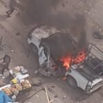 صورة لمركبة شرطة مدمرة في شارع النفق بغزة بعد استهدافها بغارة إسرائيلية، مع آثار الدمار في المنطقة المحيطة.