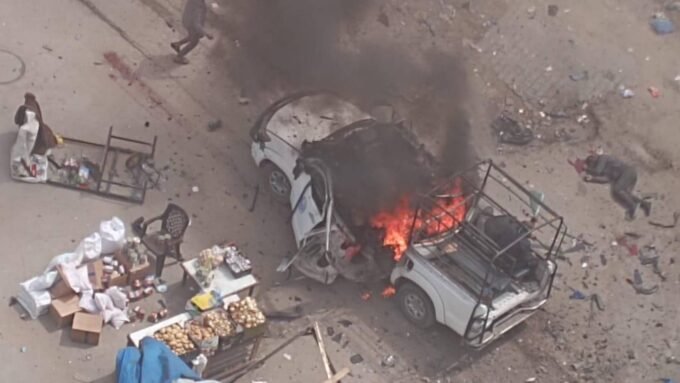 صورة لمركبة شرطة مدمرة في شارع النفق بغزة بعد استهدافها بغارة إسرائيلية، مع آثار الدمار في المنطقة المحيطة.