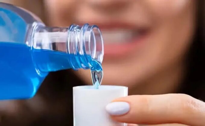 صورة توضيحية لزجاجة غسول فم بجانب قلب بشري، ترمز للعلاقة بين صحة الفم والقلب.