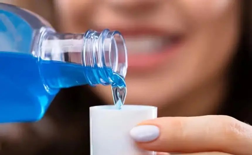 صورة توضيحية لزجاجة غسول فم بجانب قلب بشري، ترمز للعلاقة بين صحة الفم والقلب.